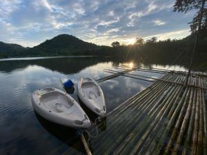 two boats are tied to a dock on a lake at Royal mountain Hut in Ratchaburi