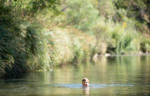 a woman swimming in the water in a river at Delphi, Adelaide Hills Garden BnB in Mylor