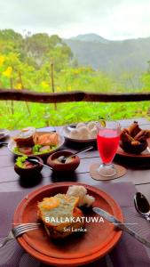 une table sur laquelle sont posées des assiettes de nourriture et une boisson dans l'établissement Shia, à Ella