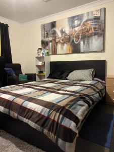 a bedroom with a bed and a painting on the wall at R n M Guest House in West Swan