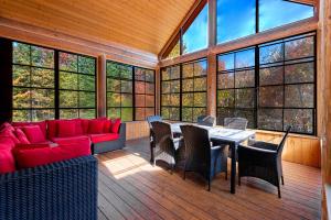 a living room with a red couch and a table at Fiddler Lake Resort - Deer 59 in Mille-Isles