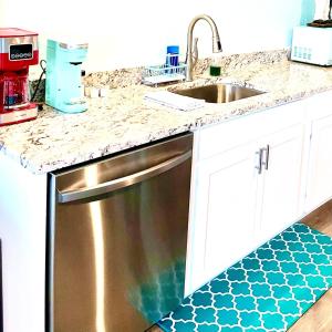 a kitchen with a stainless steel dishwasher next to a sink at Cedar Key Islands Dolphins Cay Condo in Cedar Key