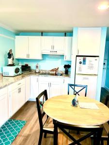 a kitchen with white cabinets and a wooden table at Cedar Key Islands Dolphins Cay Condo in Cedar Key