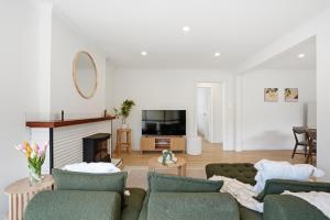 WarraneHobart Family Home near Airport & City的有两张沙发和一台电视的客厅