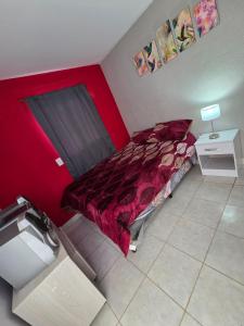 a red bed in a room with a red wall at Alisos Suite FC Torre 2 in El Ceibal +13 photos