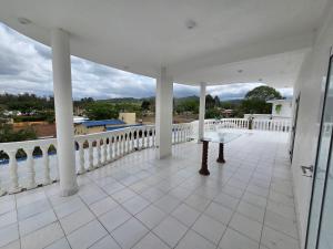a white porch with a white railing and a table at Alisos Suite FC Torre 2 in El Ceibal