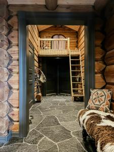 Una habitación con una cabaña de madera con una escalera y un sofá. en Family Cabin With Panoramic Views In Aurdalsåsen, en Aurdal