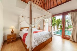 a bedroom with a canopy bed and a swimming pool at Villa Pantina Bali in Uluwatu