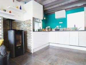 une cuisine avec des armoires blanches et un réfrigérateur noir dans l'établissement Charmante maison mitoyenne avec jardin et Wifi en campagne près de Nantes - FR-1-306-1320, à Bouvron