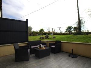 un patio avec des chaises, une table et un champ dans l'établissement Charmante maison mitoyenne avec jardin et Wifi en campagne près de Nantes - FR-1-306-1320, à Bouvron