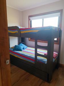 een stapelbed in een kamer met een raam bij CABAÑA CON ACCESO A RIO in Coihaique