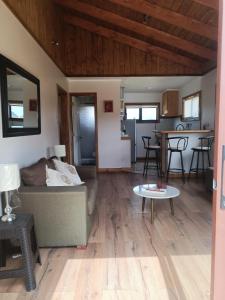 een woonkamer met een bank en een tafel bij CABAÑA CON ACCESO A RIO in Coihaique