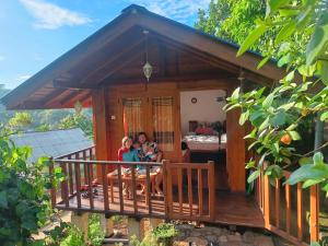 two people sitting on the porch of a tiny house at Diyaluma View Cotage in Koslanda