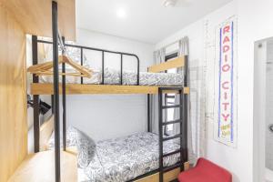 a room with two bunk beds and a red chair at JGSTAY - Times Square in New York