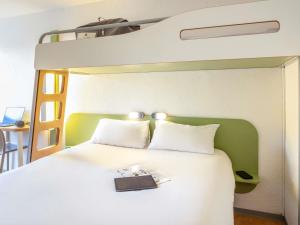 a bedroom with a bed with a book on it at ibis budget Compiègne Centre-Ville in Compiègne +49 photos