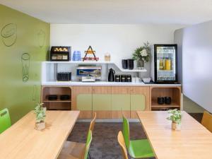 a dining room with wooden tables and green walls at ibis Budget - Campbelltown in Campbelltown