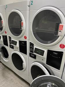 drie naast elkaar zittende wasmachines bij Nest aparthotel with kitchenette in New York