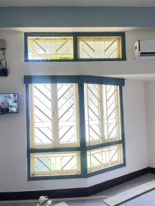 Zimmer mit 3 Fenstern in einem Gebäude in der Unterkunft Loylet Carlton in Tambaram