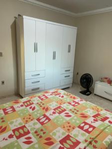 a bedroom with a bed and white cabinets at Casa do Rancho Jacuru in São Pedro da Aldeia