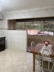 a kitchen with a table and chairs in a room at Casa do Rancho Jacuru in São Pedro da Aldeia +2 photos
