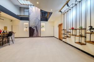 een gang met een grote glazen deur met een schilderij aan de muur bij Phoenix Geometry Light Accommodation in Fenghuang