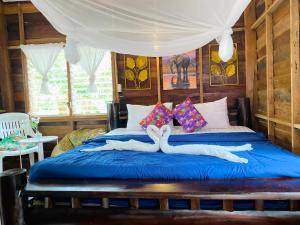 two swans laying on a bed in a room at Lucky Resort in Ko Phayam +55 photos