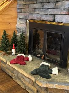 ein Kamin mit drei gestrickten Mützen auf einem steinernen Kaminsims in der Unterkunft Cabin 9- Spacious cabin- 4 King beds- 2 baths in Estes Park