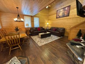 ein Wohnzimmer mit einem Sofa und einem Tisch in einer Hütte in der Unterkunft Cabin 9- Spacious cabin- 4 King beds- 2 baths in Estes Park