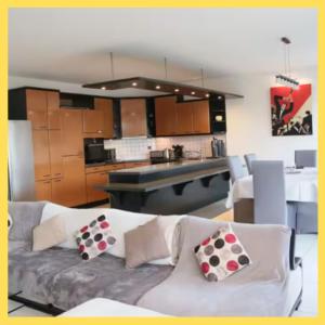 un salon avec un canapé et une cuisine dans l'établissement Magnifique T3 spacieux de 150 m carrés Vue Lac Léman, à Évian-les-Bains