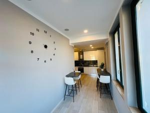 una cucina e una sala da pranzo con un orologio sul muro di Scuderia il Costa a Paratico