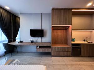 a room with a desk with a tv and a desk sidx sidx sidx at Suites Homestay by Evernent in Miri +11 photos