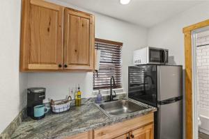 een keuken met een roestvrijstalen koelkast en een spoelbak bij Cabin15 - King bed Hotel Style Unit in Estes Park +19 foto's