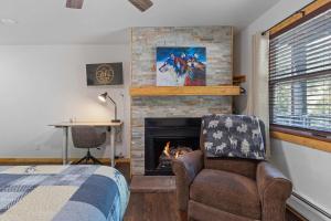 een slaapkamer met een open haard en een bed en een stoel bij Cabin16 - King Bed Kitchenette & Bath in Estes Park