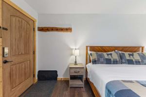 een slaapkamer met een bed, een deur en een stoel bij Cabin16 - King Bed Kitchenette & Bath in Estes Park +19 foto's