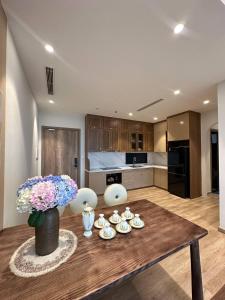 a kitchen with a wooden table with a vase of flowers at La paix home 3BR Lakefront Apartment with Balcony and Free Onsen in Kim Quan +47 photos