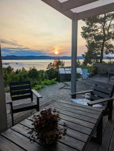 two benches on a deck with a view of the water at Cabin With Views Of The Oslofjord On Nesodden in Nordstrand