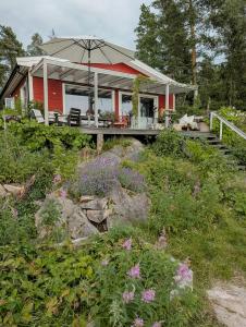 a red house with an umbrella in the yard at Cabin With Views Of The Oslofjord On Nesodden in Nordstrand +22 photos