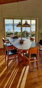 a dining room table with chairs and a large window at Cabin With Views Of The Oslofjord On Nesodden in Nordstrand