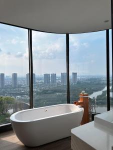 a white bath tub in a bathroom with a large window at La paix home 3BR Lakefront Apartment with Balcony and Free Onsen in Kim Quan
