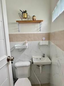 a bathroom with a toilet and a sink at The ComfyNook Hostel in Santa Maria