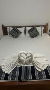 a bed with two white towels forming a heart at Mango paradise sigiriya in Dambulla