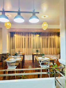 ein Esszimmer mit Tischen, Stühlen und Lichtern in der Unterkunft The ComfyNook Hostel 