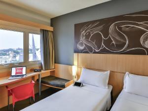 a hotel room with two beds and a desk with a laptop at ibis Goiânia in Goiânia +103 photos