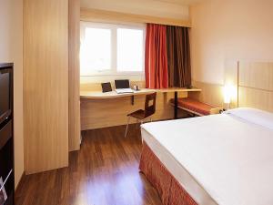 una camera d'albergo con un letto e una scrivania con un computer portatile di ibis Uberlandia a Uberlândia