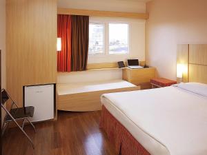 una stanza d'albergo con un letto e una finestra di ibis Uberlandia a Uberlândia Altre 52 foto