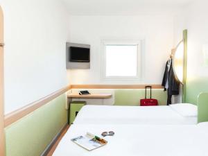 Una habitación de hospital con dos camas y un televisor. en ibis budget Beaconsfield, en Beaconsfield