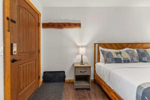 een slaapkamer met een bed, een deur en een stoel bij Cabin 17 - King Bed New Kitchen & Bath in Estes Park