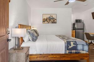 een slaapkamer met een bed en een tafel met een lamp bij Cabin 17 - King Bed New Kitchen & Bath in Estes Park