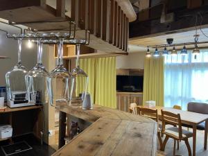 a kitchen and dining room with a table and wine glasses at Toma House in Tōma