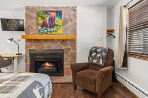 een slaapkamer met een open haard, een stoel en een bed bij Cabin 17 - King Bed New Kitchen & Bath in Estes Park